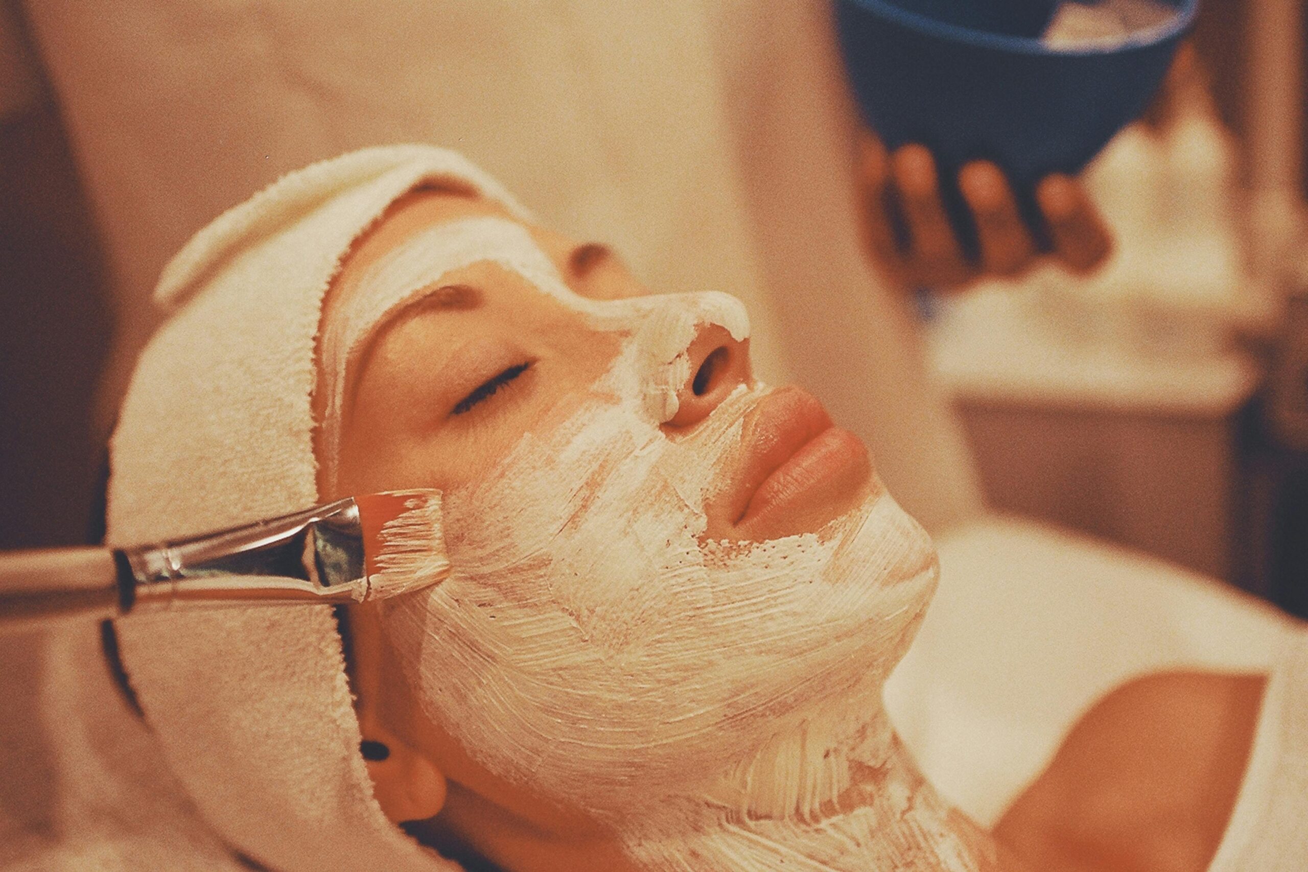 A person receiving a rejuvenating facial mask treatment in a calming spa environment.