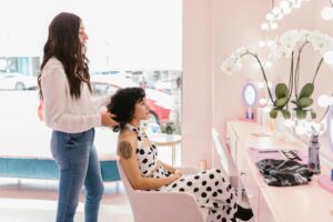 Hairstylist working with a client at a trendy salon, focusing on hairstyling and self-care.